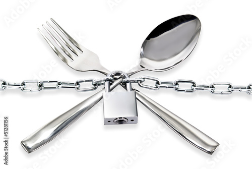 Photo: "The spoon and fork with a chain and padlock on a white ." "The spoon and fork with a chain and padlock on a white ."