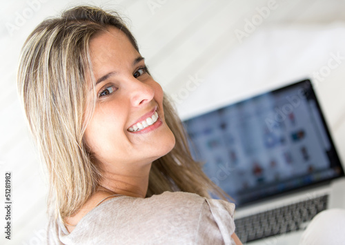 Photo: Woman using her laptop at home Woman using her laptop at home