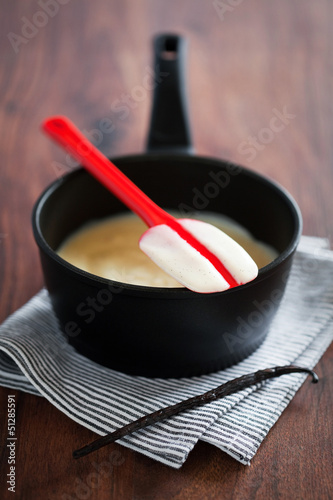 Photo: Making fresh vanilla custard in a metal pan, selective focus Making fresh vanilla custard in a metal pan, selective focus