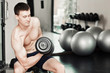 Happy man lifting weights at gym