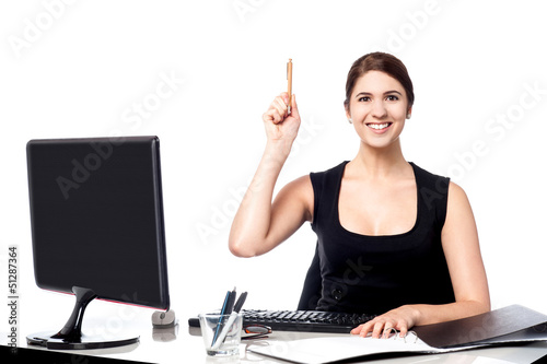 Photo: Businesswoman holding pen and raising her hand Businesswoman holding pen and raising her hand
