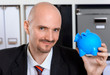 Geschäftsmann hält Sparschwein in der Hand