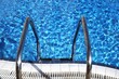 clear blue water in swimming pool with pool ladder