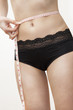 femme mesurant sa taille fine avec un mètre ruban
