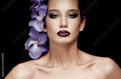 Photo: Fashionable beautiful woman with orchid in her hair Fashionable beautiful woman with orchid in her hair