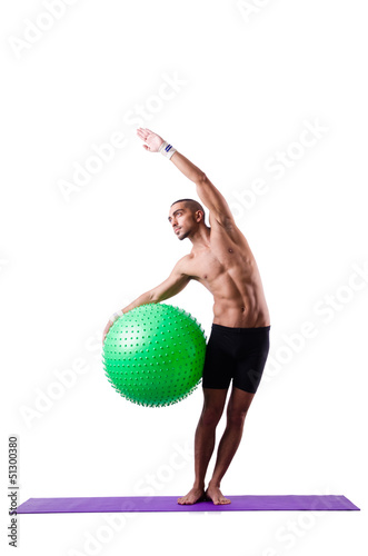 Photo: Man with swiss ball doing exercises on white Man with swiss ball doing exercises on white