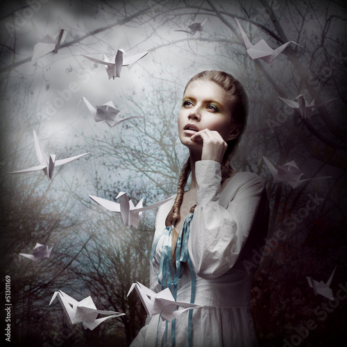 Photo: Inspiration. Woman with Flying Origami Swans in Mystic Forest Inspiration. Woman with Flying Origami Swans in Mystic Forest