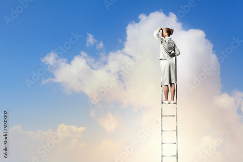 Photo: Businesswoman standing on ladder Businesswoman standing on ladder