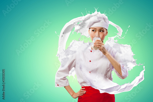 Photo: Asian female cook against milk splashes Asian female cook against milk splashes