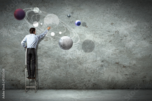 Photo: Business man drawing planets Business man drawing planets