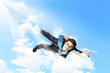 Young businessman flying with parachute on back