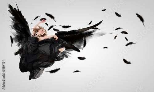 Photo: Woman floating on dark wings Woman floating on dark wings