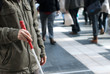 Photo: Blind person with white cane in public place Blind person with white cane in public place