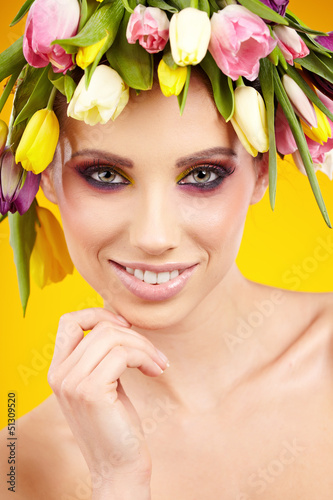 Photo: woman portrait with wreath from flowers on head over spring bac woman portrait with wreath from flowers on head over spring bac