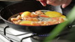 Egg frying in a pan. Adding tomato slices.