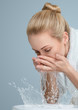 Foto: Young woman washing her face Young woman washing her face