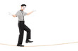 Full length portrait of a male mime artist walking on a rope