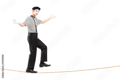 Photo: Full length portrait of a male mime artist walking on a rope Full length portrait of a male mime artist walking on a rope