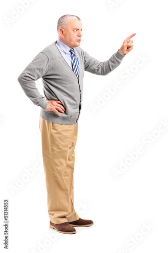 Photo: Full length portrait of an angry mature man pointing with finger Full length portrait of an angry mature man pointing with finger