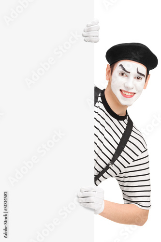 Photo: Smiling mime artist posing behind a blank panel Smiling mime artist posing behind a blank panel