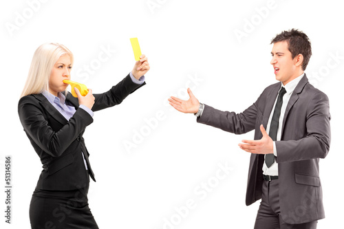 Photo: Woman in business suit showing a yellow card and blowing a whist Woman in business suit showing a yellow card and blowing a whist