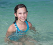 Happy tween girl in the clear ocean