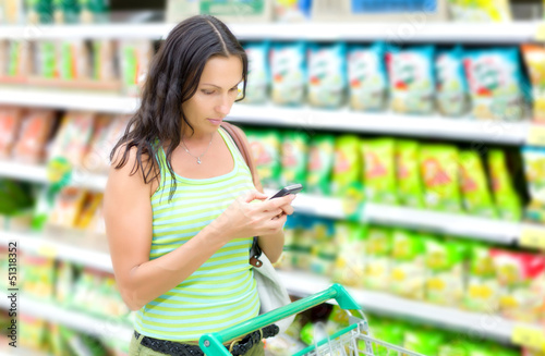 Photo: A woman reads SMS in supermarkets A woman reads SMS in supermarkets