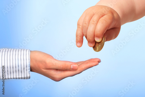 Photo: Baby's hand and coin. Baby's hand and coin.