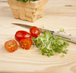 Photo: Watercress, tomatoes, knife on wooden table Watercress, tomatoes, knife on wooden table