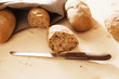 Foto: angebrochenes vollkornbrötchen mit messer vor anderen brötchen angebrochenes vollkornbrötchen mit messer vor anderen brötchen