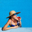 Woman at poolside with cosmopolitan cocktail