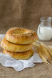 Three fresh pitas bread, ears of rye and milk jug.