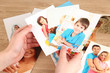 Photos in hands on wooden table