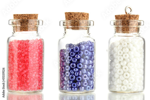 Photo: Little bottles full with colorful beads isolated on white Little bottles full with colorful beads isolated on white