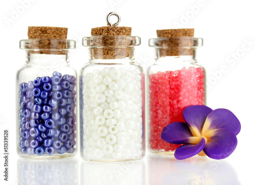 Photo: Little bottles full with colorful beads isolated on white Little bottles full with colorful beads isolated on white