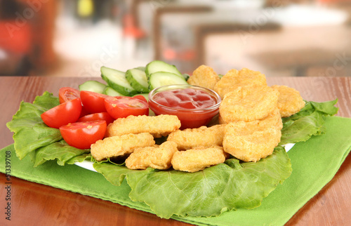 Photo: Fried chicken nuggets with vegetables and sauce on table in Fried chicken nuggets with vegetables and sauce on table in