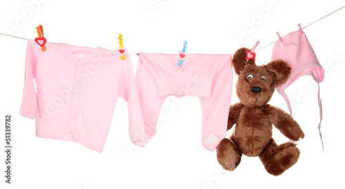 Photo: Baby clothes hanging on clothesline, isolated on white Baby clothes hanging on clothesline, isolated on white