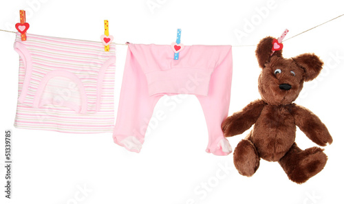 Photo: Baby clothes hanging on clothesline, isolated on white Baby clothes hanging on clothesline, isolated on white