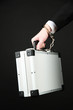Hand with handcuff and suitcase, isolated on black