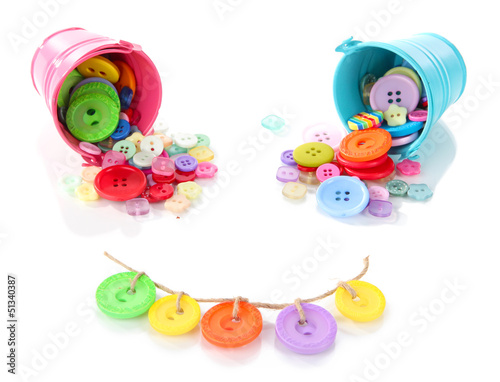Photo: Colorful buttons strewn from buckets isolated on white Colorful buttons strewn from buckets isolated on white
