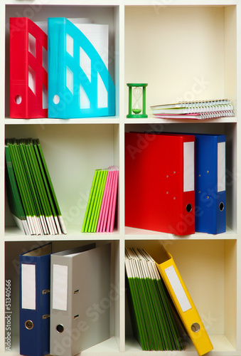 Photo: White office shelves with different stationery, close up White office shelves with different stationery, close up