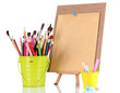 Small easel with sheet of paper with art supplies isolated