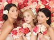 three women with background full of roses
