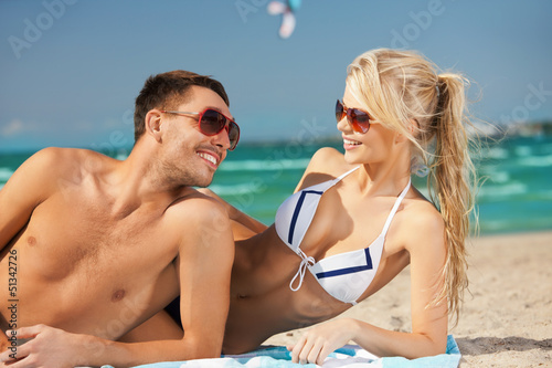 Photo: happy couple in sunglasses on the beach happy couple in sunglasses on the beach