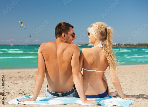 Photo: happy couple in sunglasses on the beach happy couple in sunglasses on the beach