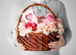 man holding basket full of flowers and postcard