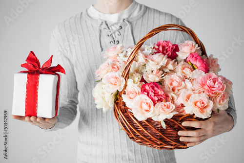 Photo: man holding basket full of flowers and gift box man holding basket full of flowers and gift box