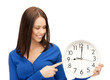 businesswoman pointing her finger at wall clock