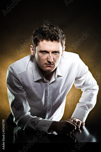 Photo: Serious man strictly looking from his workplace Serious man strictly looking from his workplace
