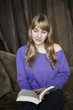 Young Woman with Beautiful Blue Eyes Reading a Book